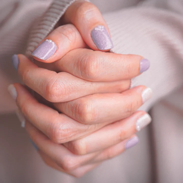 Ongles courts lavande sur des mains jointes
